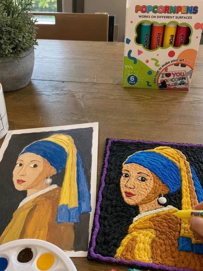 Two raised portrait paintings beside a 3D art pen set.