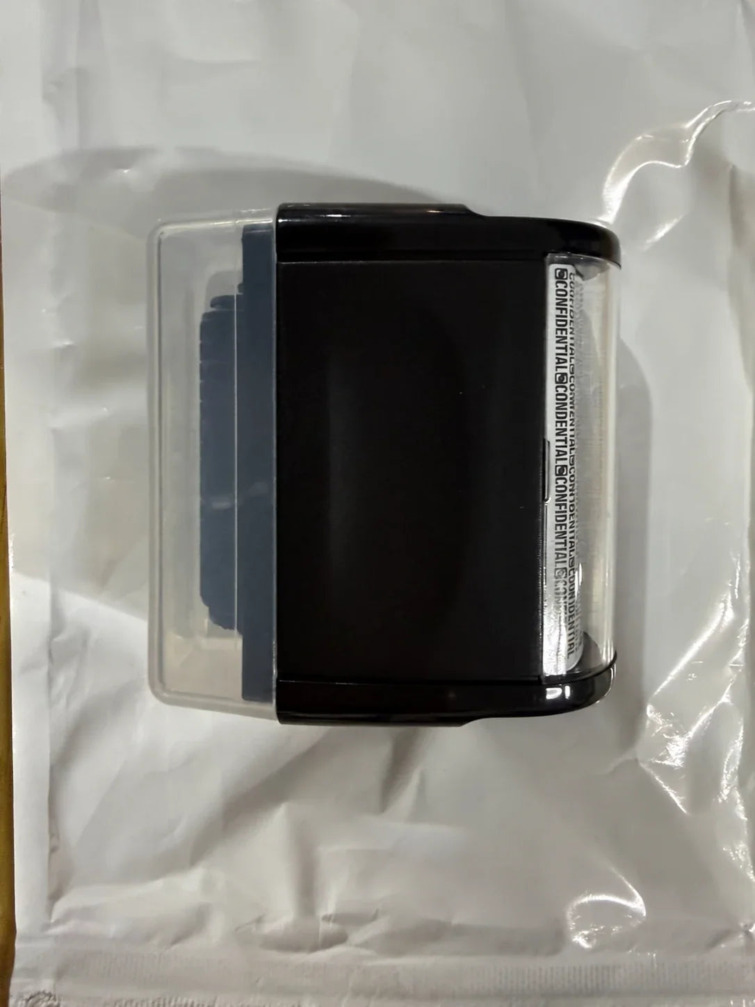 A black privacy stamp with a clear cap photographed on its packaging